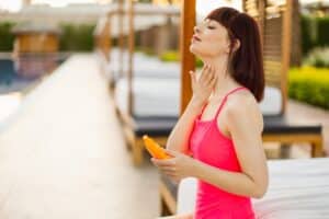 Woman reapplying sunscreen outdoors in Austin, TX
